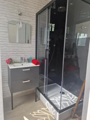 a bathroom with a glass shower with a sink at Maison pour 4 personnes en bord de mer in Borgo