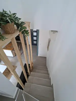 a staircase in a room with a table and plants at Maison pour 4 personnes en bord de mer in Borgo