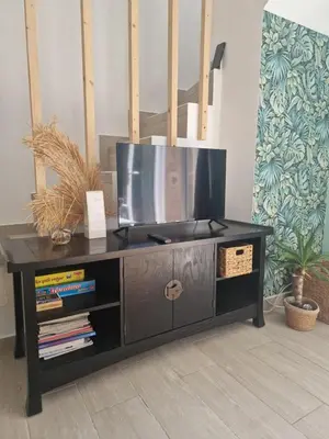 a black entertainment center with a tv on top of it at Maison pour 4 personnes en bord de mer in Borgo