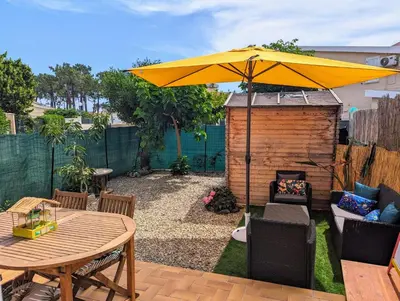 a patio with a table and a yellow umbrella at Maison pour 4 personnes en bord de mer in Borgo