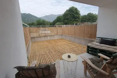 a patio with a wooden fence and a table at Casa Carlu Maria II in Corte