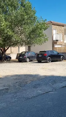 two cars parked in a parking lot next to a building at Casa Carlu Maria I in Corte