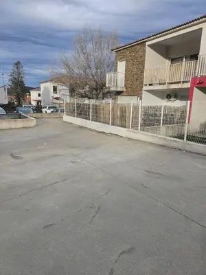 a parking lot in front of a building with a fence at Casa Carlu Maria I in Corte