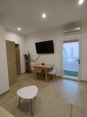 a living room with a table and a tv on the wall at Studio à la campagne in Ocana