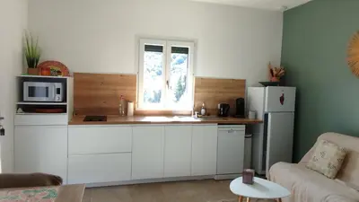 a kitchen with white cabinets and a white refrigerator at Studio à la campagne in Ocana