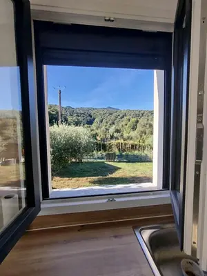a window in a kitchen with a view of a field at Studio à la campagne in Ocana
