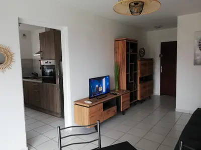 a living room with a television on a wooden cabinet at Les pieds dans l'eau in San-Nicolao