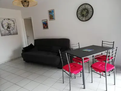 a living room with a table and chairs and a couch at Les pieds dans l'eau in San-Nicolao
