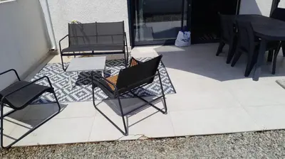 a patio with two chairs and a table and a table at Logement 5 mn de la mer Milla 2 in Ventiseri