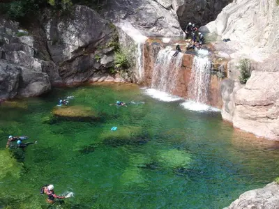 a group of people swimming in a waterfall at Logement 5 mn de la mer Milla 2 in Ventiseri
