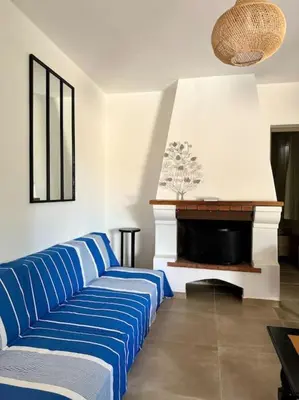a living room with a blue couch and a fireplace at Villa avec Piscine proche plages et commerces in San-Gavino-di-Carbini