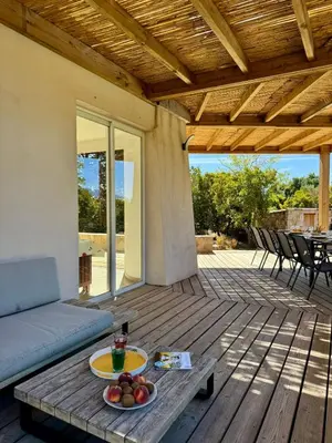 a patio with a couch and a table with fruit on it at Villa avec Piscine proche plages et commerces in San-Gavino-di-Carbini