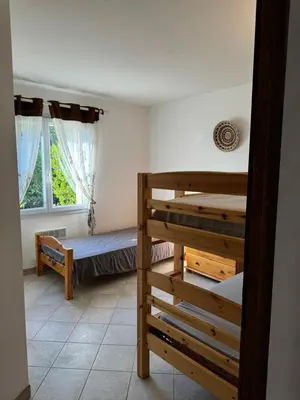 a room with two bunk beds and a window at villa arbutu in Olmeto