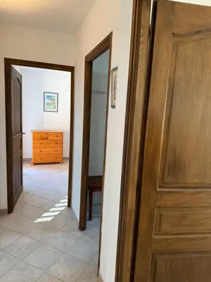 a hallway with a wooden door and a dresser at villa arbutu in Olmeto