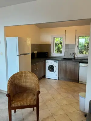 a kitchen with a refrigerator and a washing machine at villa arbutu in Olmeto