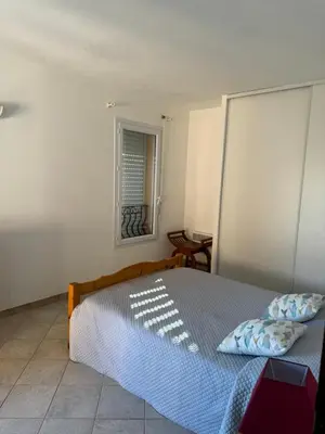 a bedroom with a bed and a window at villa arbutu in Olmeto