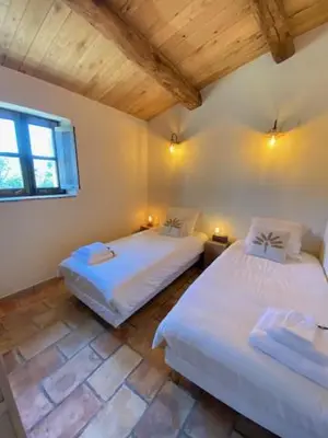 a bedroom with two beds and a window at Les Bergeries de Pinarello, Capellina in Zonza