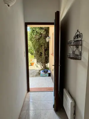 an open door to a room with a hallway with a door at Villa acula in Olmeto