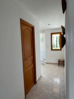 a hallway with a wooden door and a window at Villa acula in Olmeto