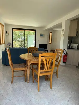 a wooden table and chairs in a living room at Villa acula in Olmeto