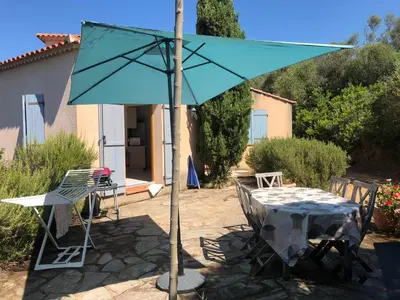 a table with a blue umbrella on a patio at Villa acula in Olmeto