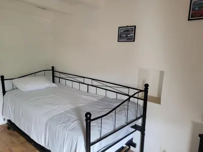 a bed in a white room with a black frame at La maison de corse in Feliceto