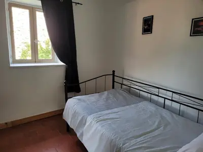 a bedroom with a bed and a window at La maison de corse in Feliceto