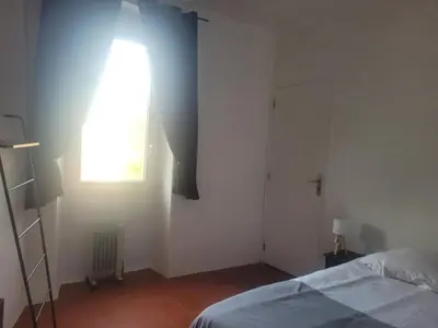 a bedroom with a bed and a window and a door at La maison de corse in Feliceto