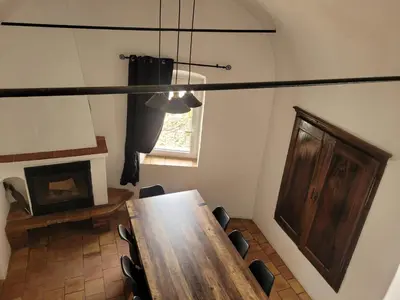 a dining room with a wooden table and chairs at La maison de corse in Feliceto