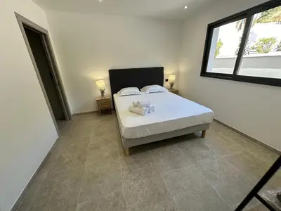 a bedroom with a bed with two stuffed animals on it at Résidence du Château d'eau in Porticcio
