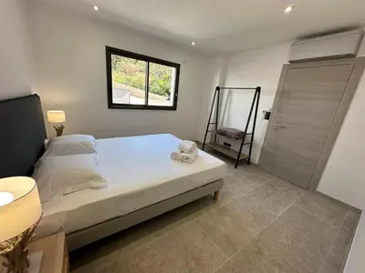 a bedroom with a bed with a teddy bear on it at Résidence du Château d'eau in Porticcio