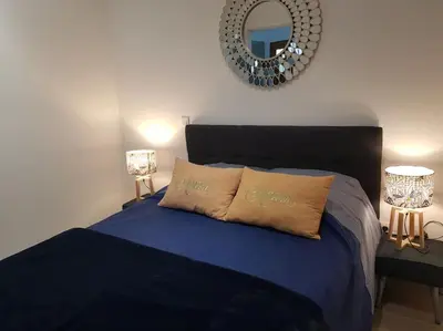 a bedroom with a blue bed with a mirror at Casa Figarella in Calenzana