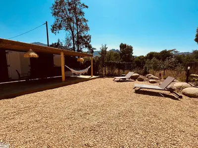 a patio with two lounge chairs and a hammock at Casa Figarella in Calenzana