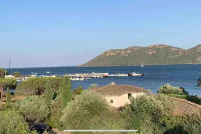a house on the shore of a body of water at Villa Pieds dans l eau in Porto-Vecchio