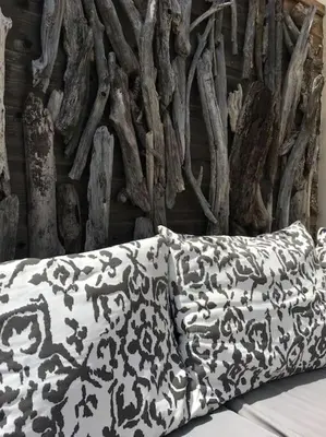 a black and white pillow sitting in front of a wall at Villa Pieds dans l eau in Porto-Vecchio