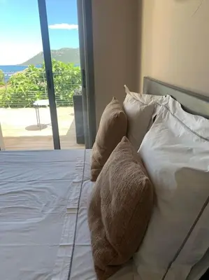 a stuffed animal is sitting on a bed at Villa Pieds dans l eau in Porto-Vecchio