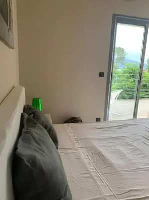 a white bed in a room with a window at Villa Pieds dans l eau in Porto-Vecchio