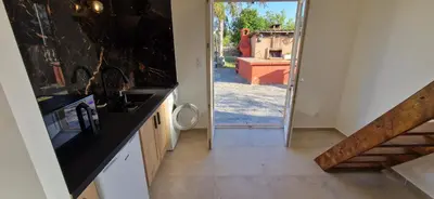 a kitchen with a sink and a door to a yard at Appartement a 5min de la plage in Penta-di-Casinca