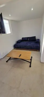 a bed with a blue couch in a room at Appartement a 5min de la plage in Penta-di-Casinca