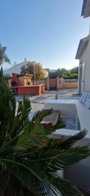 a palm tree in front of a swimming pool at Appartement a 5min de la plage in Penta-di-Casinca