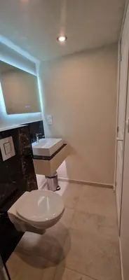 a bathroom with a white toilet and a sink at Appartement a 5min de la plage in Penta-di-Casinca