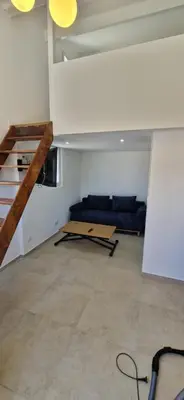 a living room with a couch and a table at Appartement a 5min de la plage in Penta-di-Casinca