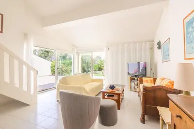 a living room with a couch and a tv at Palmeria - Maison climatisée accès direct plage in Canale-di-Verde