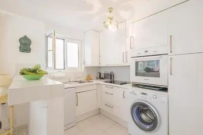 a white kitchen with a washing machine and a sink at Palmeria - Maison climatisée accès direct plage in Canale-di-Verde
