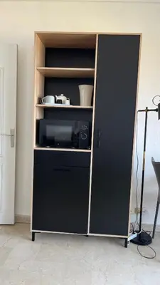a cabinet with a black refrigerator in a room at Le plein soleil in Ajaccio