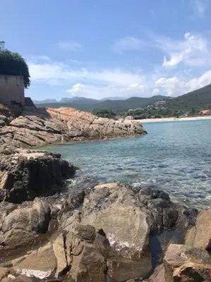 a view of a beach with rocks and the water at Appartement T3 Vue mer in Conca