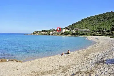 a group of people sitting on a beach at Appartement T3 Vue mer in Conca