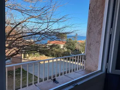a window of a balcony with a view of a mountain at Appartement T3 Vue mer in Conca
