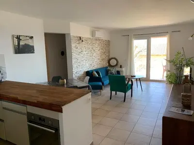 a kitchen and living room with a couch and a table at Appartement T3 Vue mer in Conca