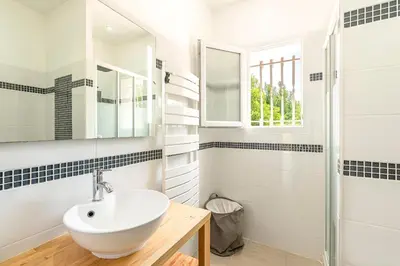 a white bathroom with a sink and a shower at La Belle-Hélène - Proche plage, 30 min d'ajaccio in Albitreccia